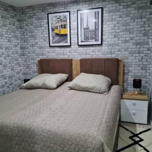 uma cama com duas almofadas num quarto com uma parede de tijolos em Elias Ruheoase em Pfungstadt