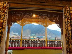 a window with a canopy with a view of a mountain at Heritage Amina Group Of Houseboats in Srinagar