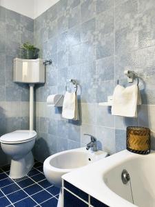 bagno piastrellato blu con servizi igienici e lavandino di Ca'Mia - Rooms a Porto Tolle