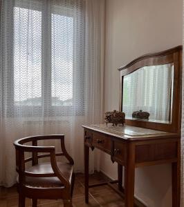 a dressing table with a mirror and a chair at Ca'Mia - Rooms in Porto Tolle +15 photos