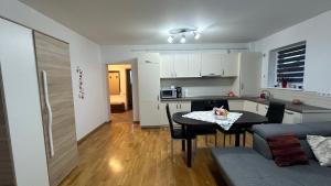 een keuken en een woonkamer met een tafel en een bank bij VDK Apartament Swiss Village in Sibiu