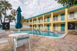 una piscina in un hotel con un tavolo e un ombrellone di Malyn 122, Waterfront condo, few blocks to beach a St Pete Beach