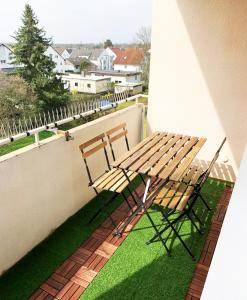 a wooden table and two chairs sitting on a balcony at Perfekt für 1, 2 und bis zu 6 Personen - Nah am Flughafen, Frankfurt City, Wiesbaden und Rüsselsheim in Mörfelden-Walldorf