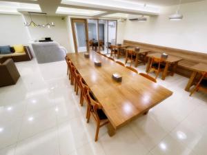 Habitación grande con mesa de madera grande y sillas. en 波斯卡朵民宿, en Magong
