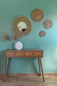 a dressing table with a mirror on a blue wall at Terra Calma Residence in Karistos
