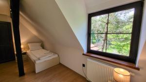 um quarto no sótão com uma janela e um radiador em Domek Zacisze em Graboszyce