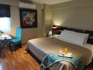 een hotelkamer met een bed en een blauwe stoel bij Hotel Vila Santa in Lima