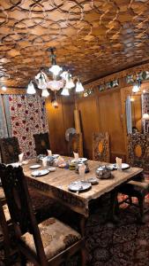 un tavolo in legno in una stanza con sedie e una sala da pranzo di Heritage Houseboats Kashmir a Srinagar