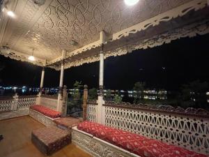 balcón con bancos rojos y vistas a la ciudad en Heritage Houseboats Kashmir, en Srinagar