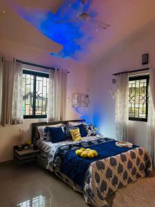 um quarto com uma cama com um tecto azul em The Source em Goa