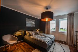 a bedroom with a bed and a chair in it at Eigene Sauna 2 Schlafzimmer sehr zentral WinterbergHome in Winterberg