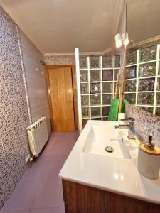 uma casa de banho com um lavatório branco num quarto em Casa de la tía Irene em Briñas