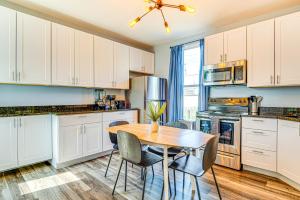 a kitchen with white cabinets and a wooden table and chairs at Home Near Downtown and Lucas Oil Stadium! in Indianapolis