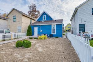 a blue house with a white fence in a yard at Home Near Downtown and Lucas Oil Stadium! in Indianapolis