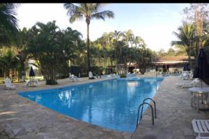 una piscina in un resort con palme di Casa 84 Condomínio fechado de frente para praia - Boiçucanga SP a São Sebastião