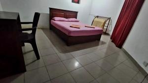 a bedroom with a bed and a table and a chair at Hotel City Light Budget in Colombo