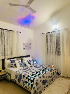 um quarto com uma cama e uma ventoinha de tecto em The Source em Goa