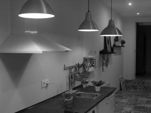 una cocina con dos luces colgantes y un lavabo en Casa al lado de la playa santa marta baiona, en Baiona