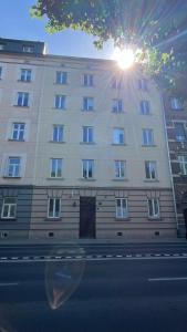 un gran edificio blanco con el sol brillando en él en Good Vibes Only, en Cracovia