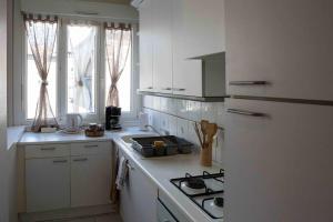 a kitchen with white cabinets and a stove top oven at ginalia cottage in Éclaron