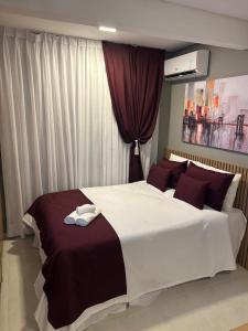 a bedroom with a large bed with towels on it at Studios London in Resende +58 photos