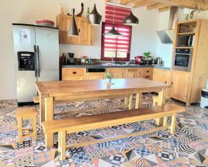 uma cozinha com uma mesa de madeira e um frigorífico em La ROSÉE des Cévennes Gîte 120m2 à 5min d'Anduze em Massillargues-Attuech