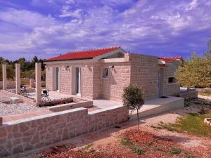 una pequeña casa de ladrillo con una pared de piedra en Villa Maginja en Sutivan