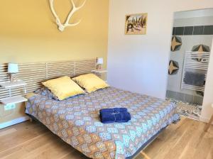 Un dormitorio con una cama con una bolsa azul. en La ROSÉE des Cévennes Gîte 120m2 à 5min d'Anduze en Massillargues-Attuech