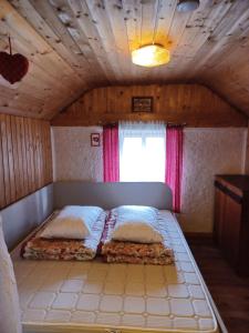 sypialnia z łóżkiem w pokoju z sufitem w obiekcie Počitniška hiša Perme w mieście Šentjanž