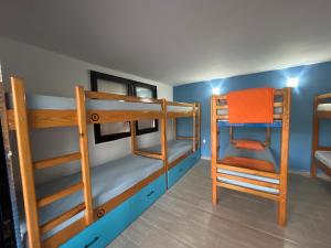 a room with three bunk beds and a chair at Blue Orange Lake Hostel in Ohrid