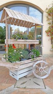 une charrette en bois remplie de nombreuses plantes dans l'établissement Arca Hotel, à Pienza