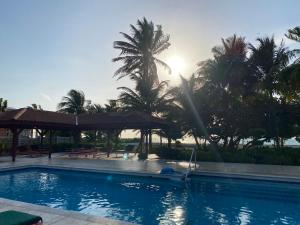 una piscina con palmeras en el fondo en St. George's Caye Resort en Ciudad de Belice