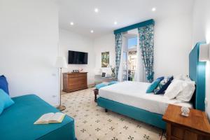 1 dormitorio con 1 cama azul y 1 sofá azul en Sorrento Shine House, en Sorrento