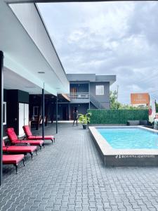 a patio with red chairs and a swimming pool at Pavema Apartments in Paramaribo