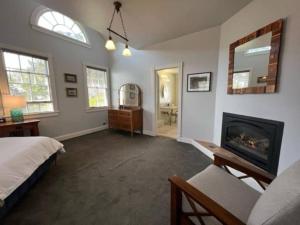 1 dormitorio con 1 cama y chimenea en Historic Coast Guard House and Cottages, en Point Arena