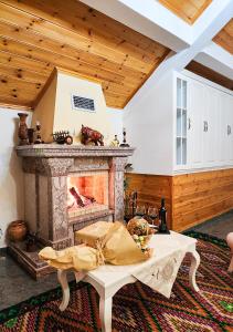 a living room with a fireplace and a table at Villa Parku Rinia in Korçë