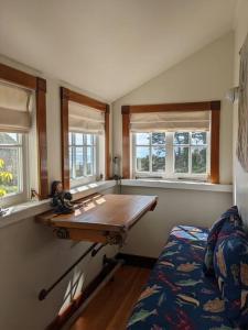 Habitación con mesa, cama y ventanas. en Historic Coast Guard House and Cottages, en Point Arena