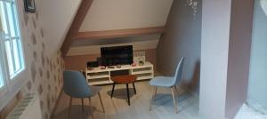 een kleine kamer met een bureau en 2 stoelen bij HIBISCUS in Malaunay