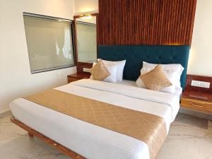 a bedroom with a large bed with a blue headboard at Nisarga Lake Resort in Satara