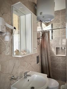 a bathroom with a sink and a toilet and a mirror at Apartmens Xhenis Lux in Ulcinj