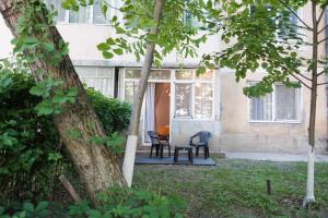 a house with two chairs and a table in a yard at Konstanzer Tudor 3 - 2 camere, bucatarie, masina de spalat in Iaşi