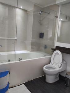 a bathroom with a toilet and a tub with a shower at Puertas de San Antonio in Cali