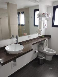 a bathroom with a sink and a toilet and a mirror at Puertas de San Antonio in Cali