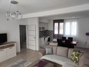 a living room with a couch and a dining room at Zelena Maslina in Bar