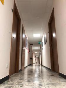 an empty hallway in an office building with doors at Hotel San Marco in Savona