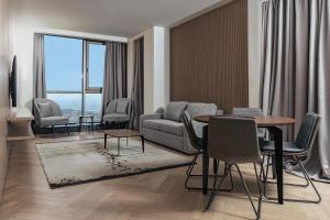 a living room with a couch and a table and chairs at Faqra Hills Hotel in Kfardebian