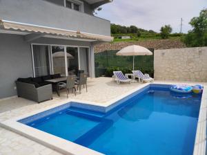 a swimming pool in front of a house at Zelena Maslina in Bar