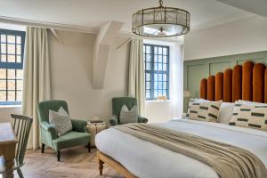 a bedroom with a large bed and two green chairs at The Store in Oxford +37 photos