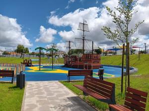 a park with benches and a playground with a pirate ship at Hospedaria São João in Vidigueira