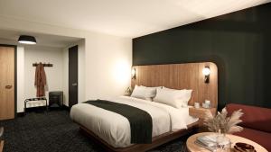 um quarto com uma cama grande e um sofá em Northwinds Hotel Revelstoke em Revelstoke